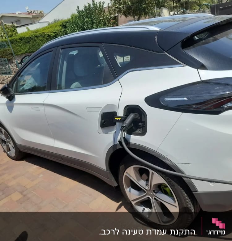 רכב חשמלי נטען עם כבל טעינה מחובר